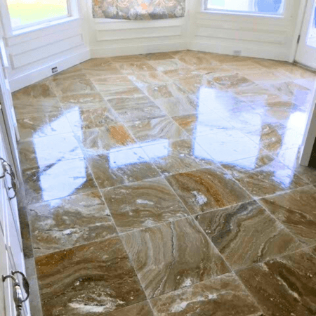 Natural polished stone tile flooring in warm tones installed in a breakfast nook