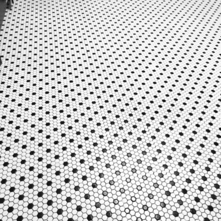 Geometric black and white hexagon tile floor installed in a residential bathroom